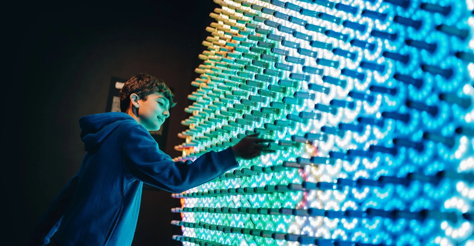 Niño interactuando con una instalación de luces digitales